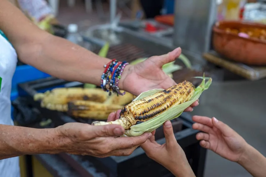 Culinary Heritage Unveiled: 4 Must-Try Delicacies in Oaxaca, Mexico 4 Person selling charcoal grilled elote corn Oaxacan street food